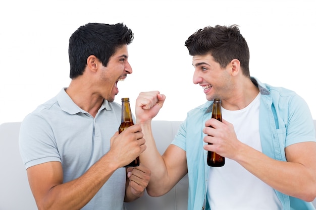 Felices fanáticos del fútbol animando junto con cervezas