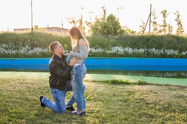 Foto felices futuros padres sonrientes en el paseo en el parque de otoño.