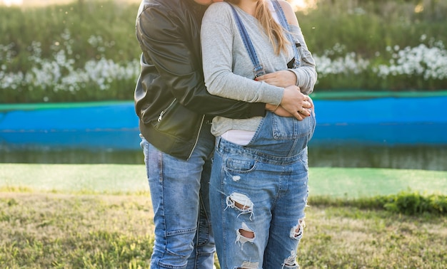 Felices futuros padres sonrientes en el paseo en el parque de otoño.