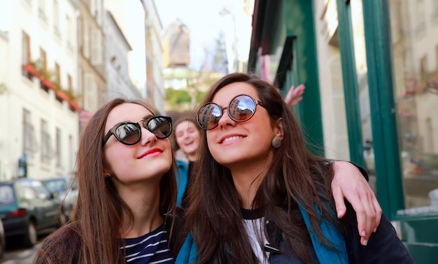 Felices y hermosas chicas estudiantes en París en la calle