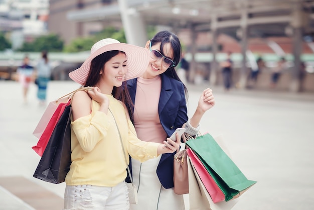 Felices hermosas mujeres jóvenes con bolsas de compras en la ciudad