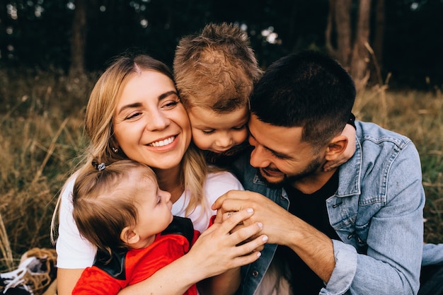 Felices hombres y mujeres jugando con niños afuera