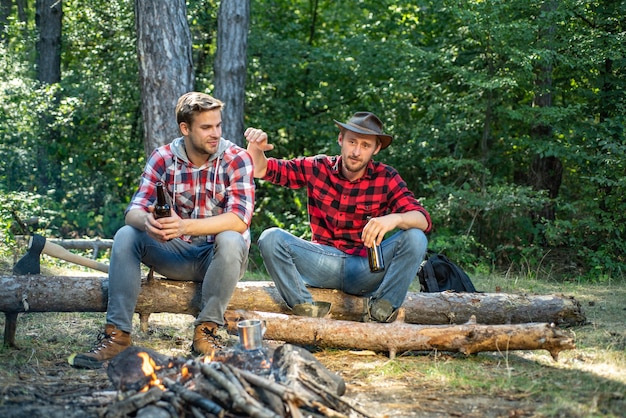 Felices los jóvenes acampando en el bosque de verano estilo de vida chico joven que tiene un picnic disfrutando de camping holi ...