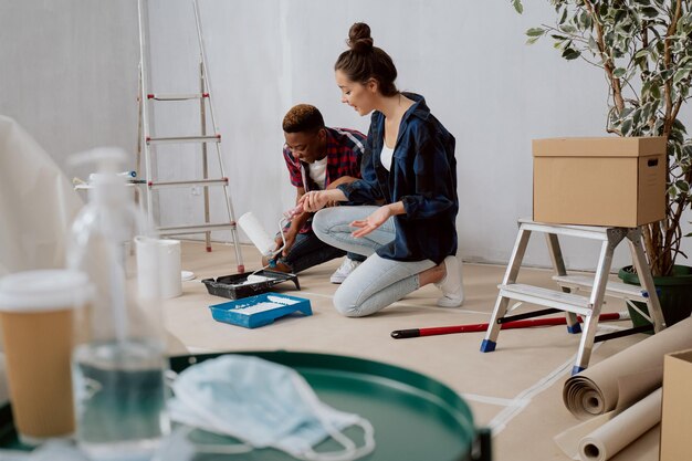 Felices jóvenes enamorados están renovando su primer apartamento comprado