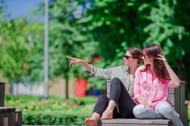 Felices jóvenes urbanas en ciudad europea. Mujeres hermosas caucásicas divirtiéndose juntos al aire libre