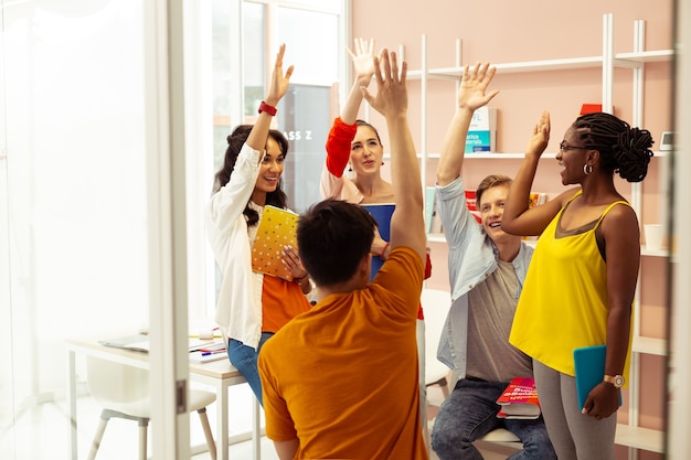 Foto felices juntos. estudiantes alegres de carreras mixtas que se sienten felices mientras pasan los exámenes