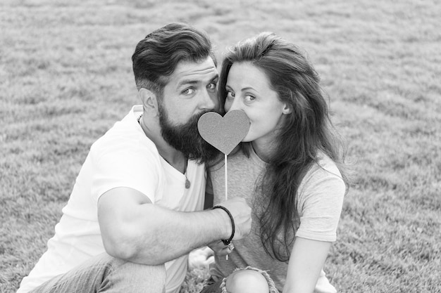 Felices juntos Pareja enamorada Relajada y enamorada Pareja relajándose en la hierba disfrutando el uno del otro Hombre barbudo hipster y mujer bonita enamorada Vacaciones de verano Enamórate Felicidad de verano