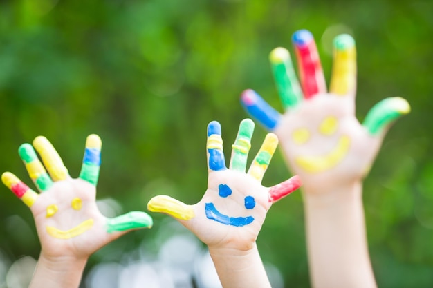 Felices manos sonrientes contra el fondo verde de la primavera