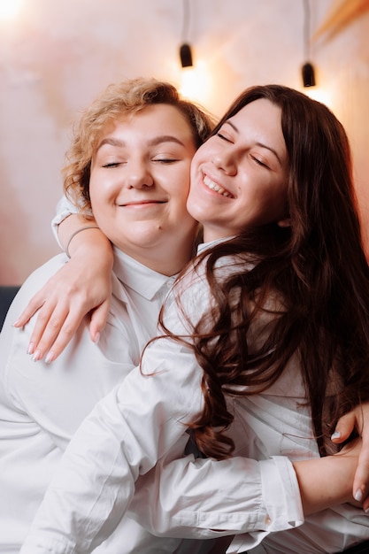 Felices mujeres jóvenes con camisas blancas y jeans celebración día de la mujer