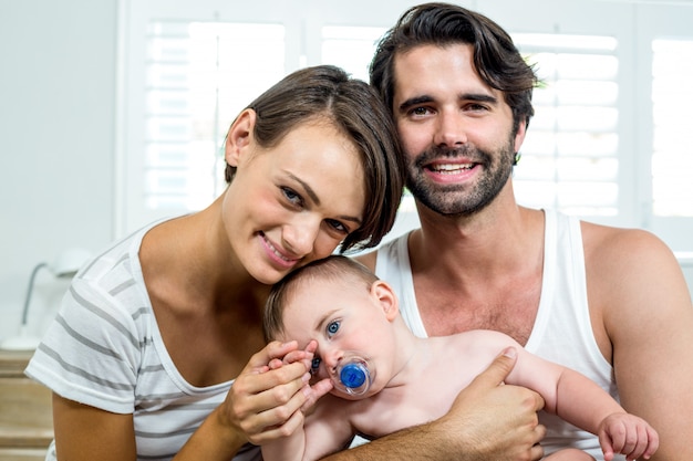 Felices padres con bebé en el dormitorio