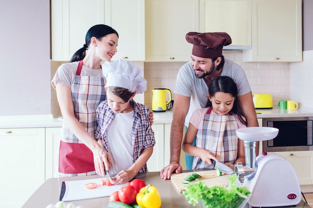 Felices padres están detrás de sus hijos y sonriendo.