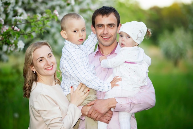 Felices padres mamá y papá hija e hijo familia joven al aire libre en primavera