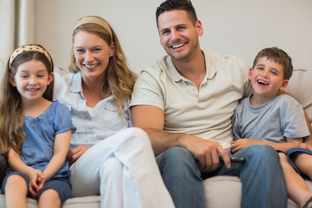 Felices padres y niños sentados en el sofá