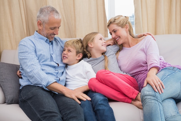 Felices padres con sus hijos en el sofá