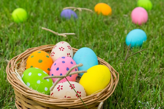 Felices Pascuas. El colorido de los huevos de Pascua en el nido sobre fondo verde hierba.