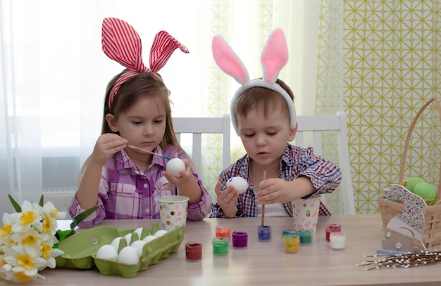 Felices pascuas divertidos niños divertidos con orejas de liebre preparándose para las vacaciones Niños celebrando la decoración del hogar de Pascua