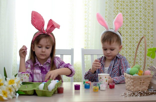 Felices pascuas divertidos niños divertidos con orejas de liebre preparándose para las vacaciones Niños celebrando la decoración del hogar de Pascua