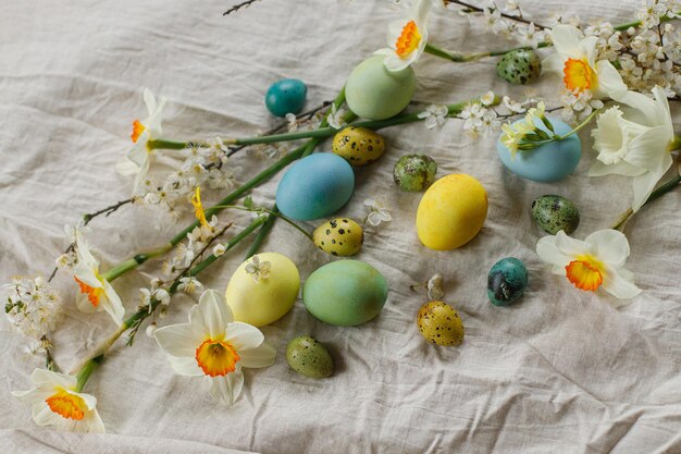 Felices Pascuas Elegantes huevos de Pascua y flores de primavera en flor en una mesa rústica Bodegón rústico de Pascua Huevos pintados naturales y narcisos florecen en tela de lino