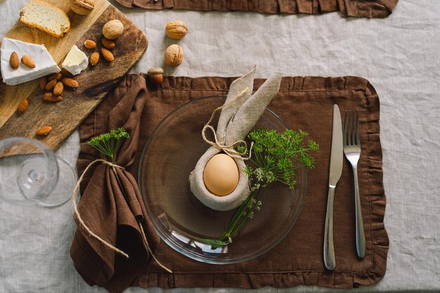 Felices Pascuas Elegantes huevos de Pascua en una servilleta con flores de primavera sobre fondo blanco de madera Ajuste de la tabla El concepto de unas felices vacaciones de Pascua