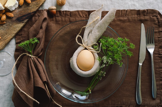 Felices Pascuas Elegantes huevos de Pascua en una servilleta con flores de primavera sobre fondo blanco de madera Ajuste de la tabla El concepto de unas felices vacaciones de Pascua