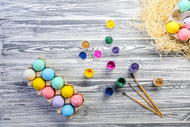 Felices Pascuas. Huevos de colores en la cesta. Decoración de mesa para vacaciones. Vista superior.