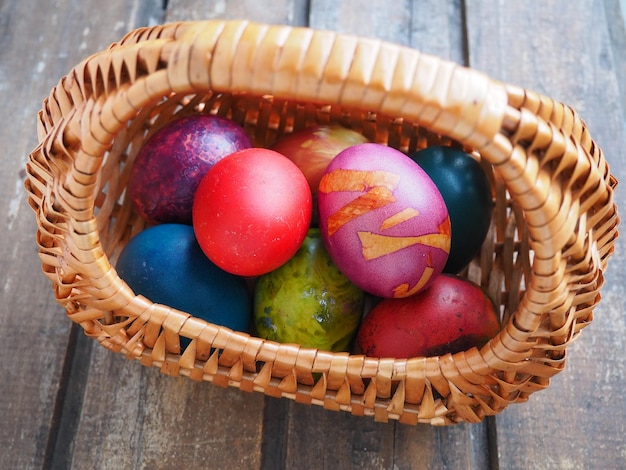 Felices Pascuas Huevos de Pascua de colores en una cesta de mimbre sobre una mesa de madera Pascua la Resurrección de Cristo la Brillante Resurrección de Cristo la fiesta más antigua y cristiana