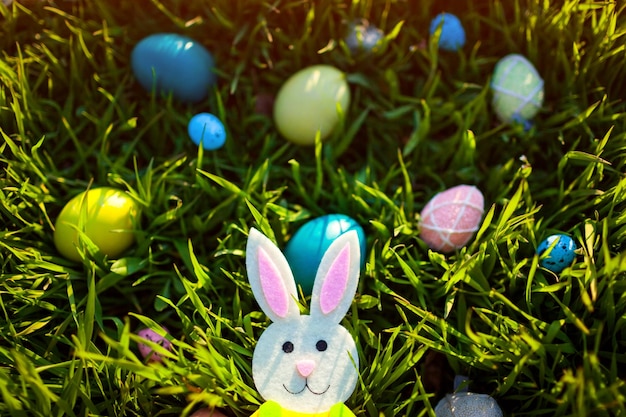 Felices Pascuas. Huevos de Pascua escondidos en la hierba de primavera. Juguete de conejito dejado en el jardín. decoración navideña