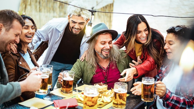 Foto felices personas de edades mixtas bebiendo y brindando cerveza en el restaurante del bar de la cervecería concepto de estilo de vida de bebidas con amigos hombres y mujeres divirtiéndose juntos afuera en el patio del jardín filtro vívido brillante