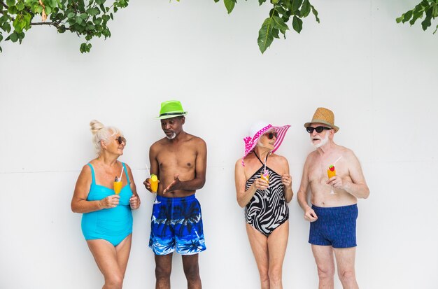 Felices las personas mayores de fiesta en la piscina Amigos mayores en una fiesta en la piscina durante el verano