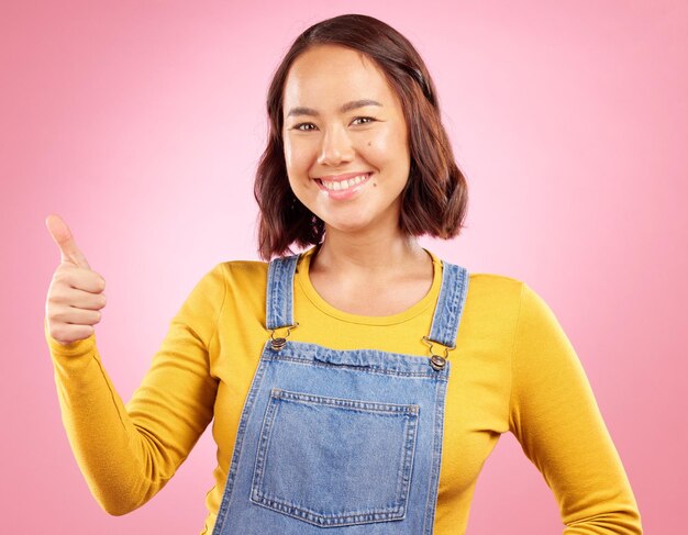 Felices pulgares arriba y sí con retrato de mujer en estudio por acuerdo de apoyo y motivación Ganador emoji y éxito con persona de fondo rosa por logro gracias y signo de voto