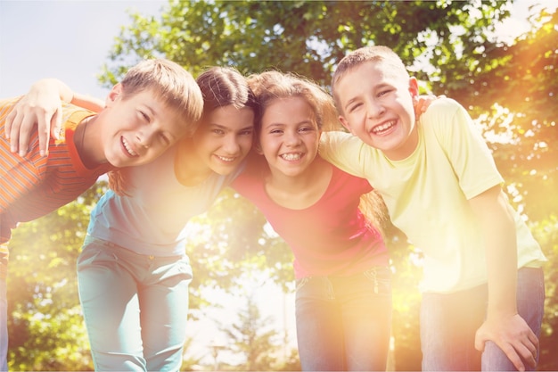 Felices sonrientes niños diversos abrazándose en el parque