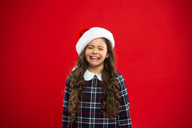 Felices vacaciones de invierno Niña pequeña con sombrero rojo de Papá Noel Fiesta de año nuevo Niño de Papá Noel Presente para Navidad Infancia Compras navideñas divirtiéndose