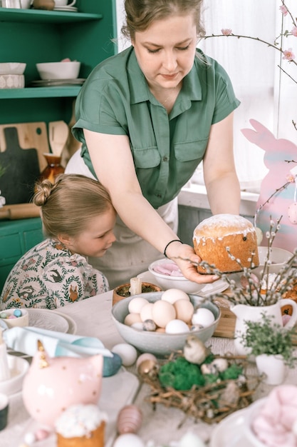 Felices vacaciones de pascua en la temporada de primavera, familia, niños, niñas, niños, hermanas y mujeres jóvenes sostienen pasteles horneados o pan tradicional en sus manos, comida tradicional hecha a mano, decoración festiva del hogar