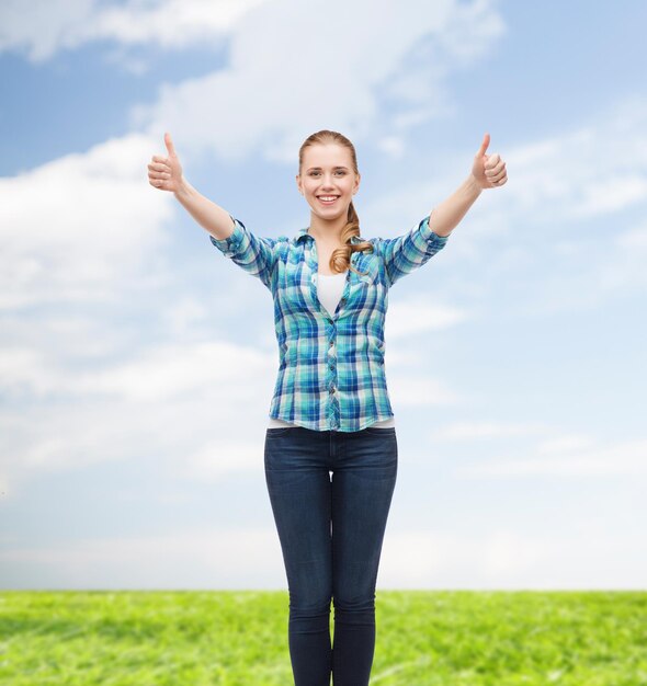 felicidad y concepto de la gente - chica sonriente con ropa informal mostrando los pulgares hacia arriba