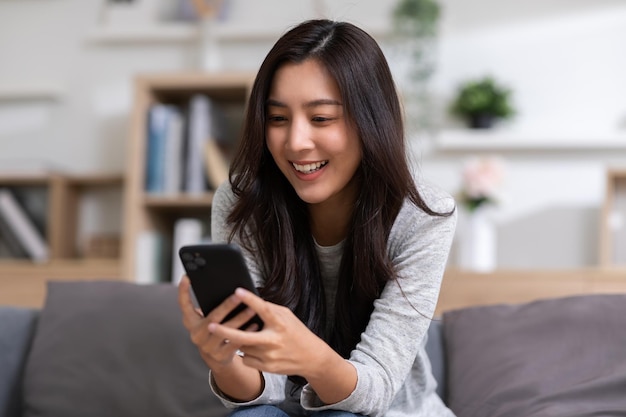 Felicidad Emprendedora hermosa mujer de negocios joven asiática usar casual usar teléfono móvil para comprar en línea disfrutar con redes sociales y portátil en casa Emprendimiento pequeño Comenzar banca en línea