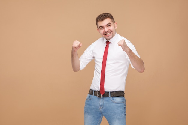 Felicidad empresario regocijo ganar. Concepto de gente de negocios, buenas y malas emociones y sentimientos. Foto de estudio, aislado sobre fondo marrón claro