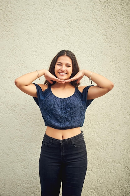 Foto la felicidad es algo que tienes que crear por ti mismo retrato de una adolescente feliz posando contra una pared exterior