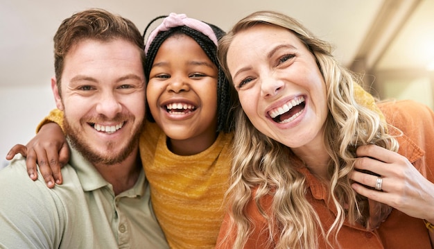 Felicidad familiar y amor con un retrato para apoyo de cuidado y tiempo de calidad después de la adopción con madre padre e hijo adoptivo juntos en su hogar Sonrisa facial y confianza de hombre mujer y niña