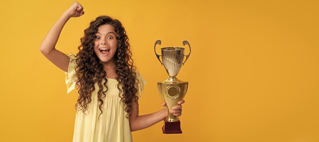 Foto felicidad feliz asombrado jovencita mantenga copa de oro premio logro cartel horizontal de aislado