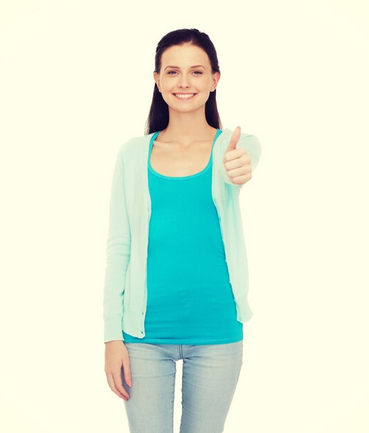 Foto felicidad, gesto y concepto de la gente - adolescente sonriente con ropa informal mostrando los pulgares hacia arriba