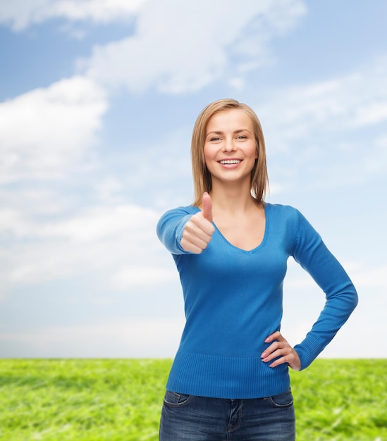 felicidad, gesto y concepto de la gente - mujer joven sonriente con ropa informal mostrando los pulgares hacia arriba