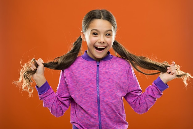 Foto felicidad infantil. familia. moda infantil y ropa deportiva. niña feliz con el pelo largo. día del niño. retrato de niño feliz. niña pequeña. peluquería para niños. pequeño soñador.