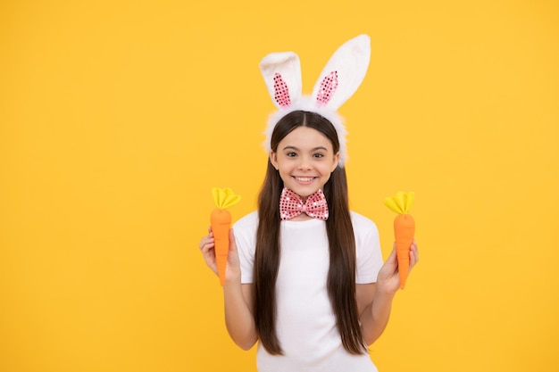 felicidad infantil. niño con orejas de conejo y pajarita. Hora de divertirse. niño adorable que se ve divertido con zanahoria. fiesta pascual de primavera. una adolescente feliz usa orejas de conejo. Felices Pascuas.