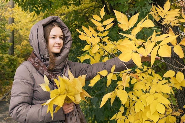 Felicidad joven hermosa chica con hojas amarillas Colores del estilo de vida de la temporada de otoño otoño