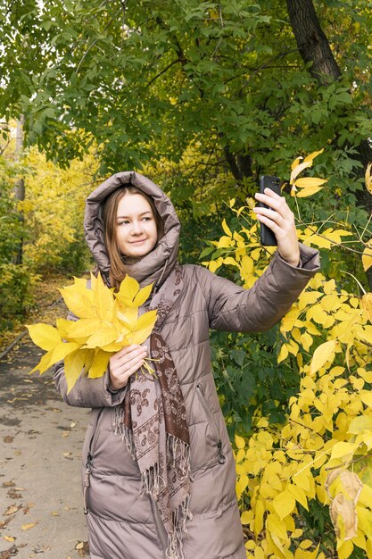 Felicidad joven hermosa chica con teléfono móvil Colores del estilo de vida de la temporada de otoño otoño