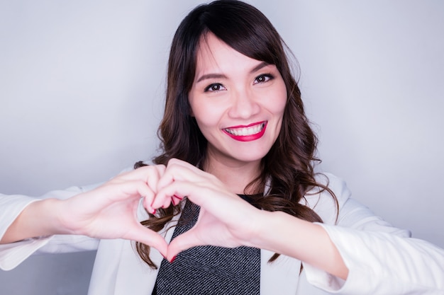 Felicidad y mujer asiática alegre con mano hacen signo de forma de corazón concepto de amor medio