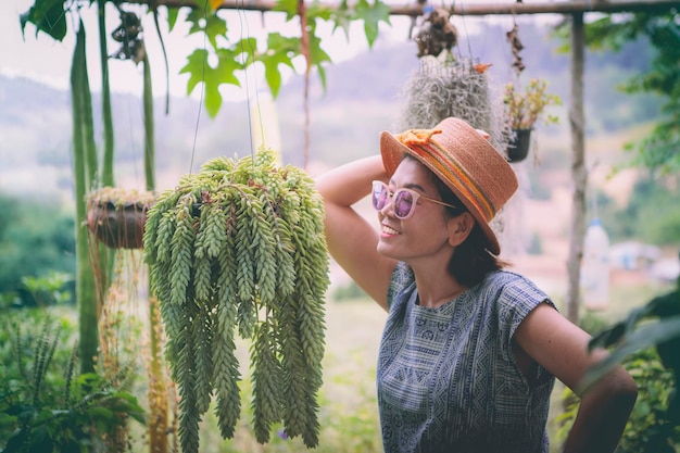 Felicidad de la mujer asiática y olla suculenta colgante