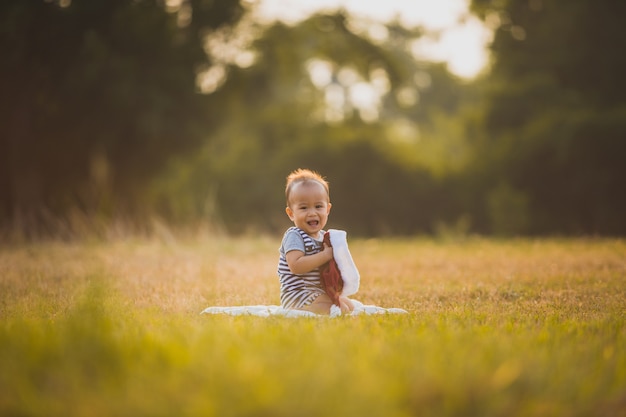 Felicidad Niño sentado en el césped en el campo