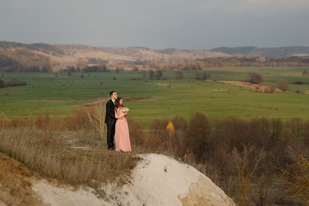 Felicidad pareja en el día de la boda caminando al aire libre.