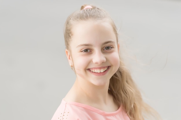 Felicidad para todos. Niño feliz con adorable rostro sonriente. Pequeña niña con cabello largo y rubio y linda sonrisa que brilla de felicidad. Concepto de felicidad. Los niños traen tanta felicidad.